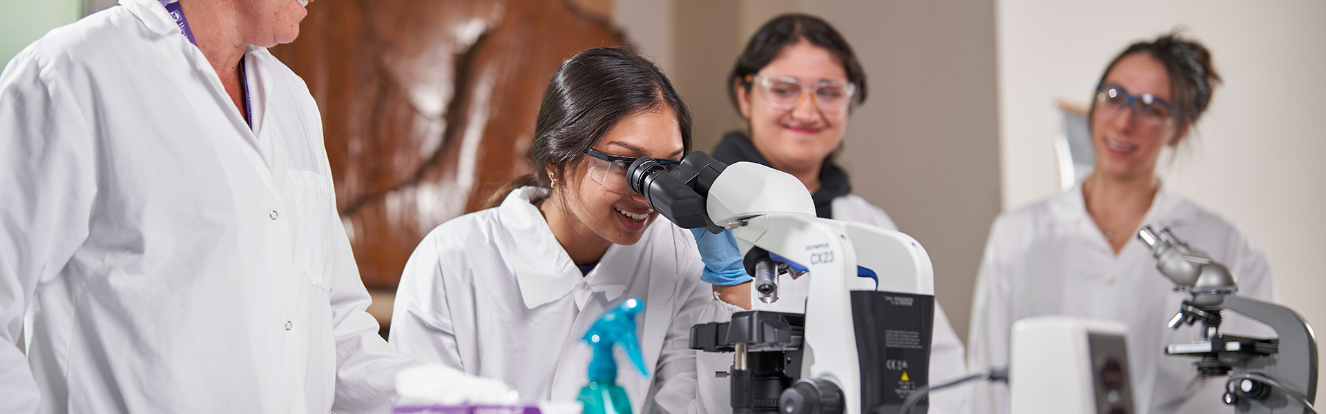 Students looking in a microscope in a lab
